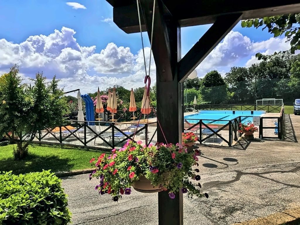 Tettoia esterna con tavoli e vista sulla piscina