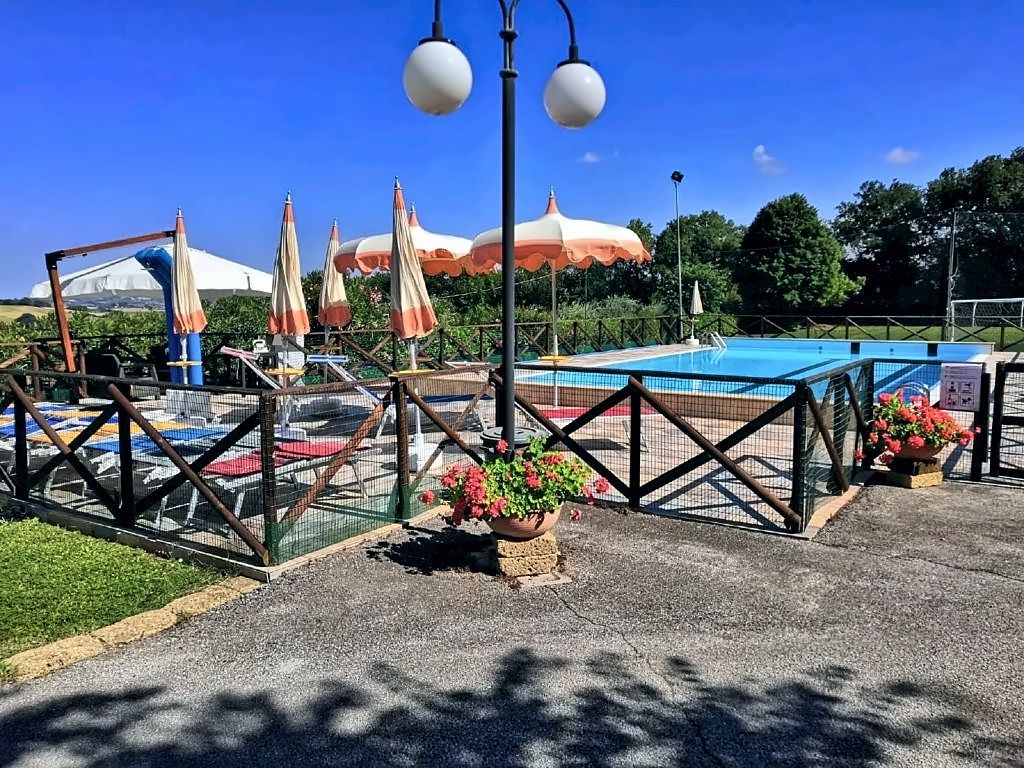 Piscina a corsie della villa con solarium e ombrelloni